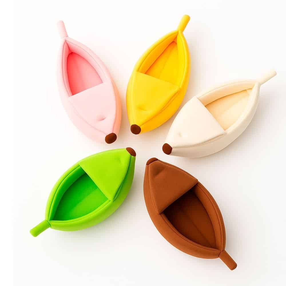 Five colorful banana-shaped plush cat beds arranged on a white background